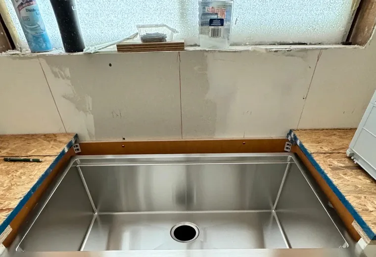 Apron-front kitchen sink and faucet installation preparation for a San Jacinto plumbing customer